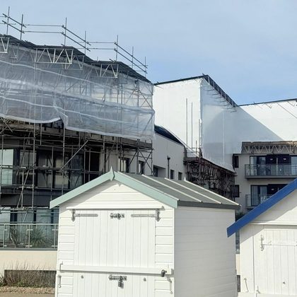 Scaffold shrink wrap beside seafront beach huts