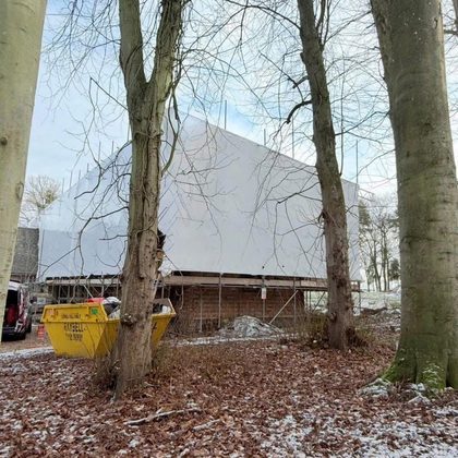 Wrapped structure seen through winter trees