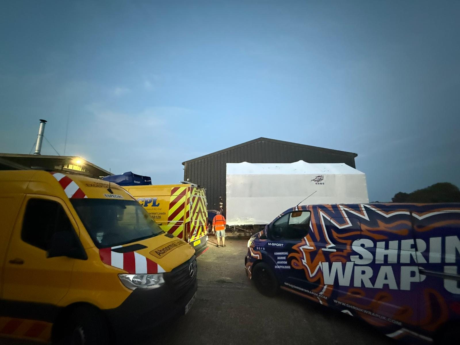 Escort vehicles and the Shrink Wrap UK van beside the wrapped load