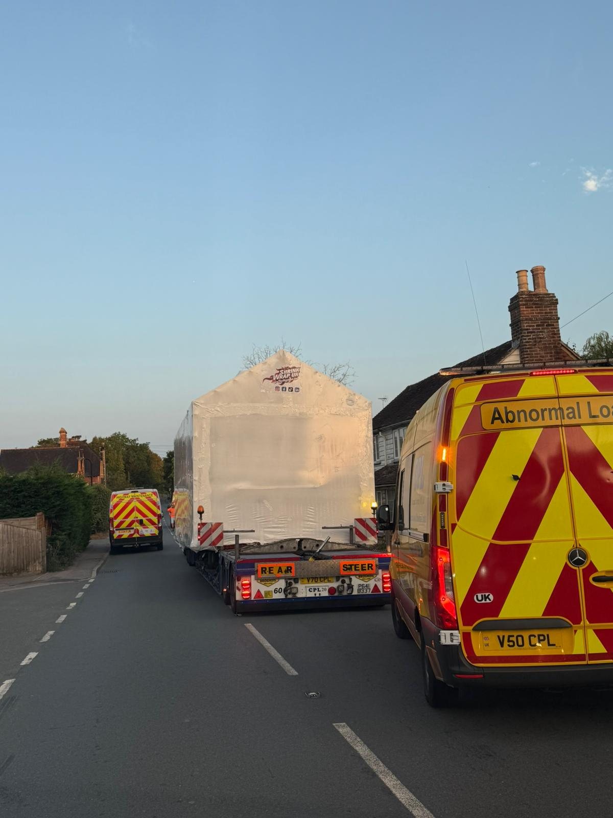 Wrapped load on the road behind an abnormal load escort