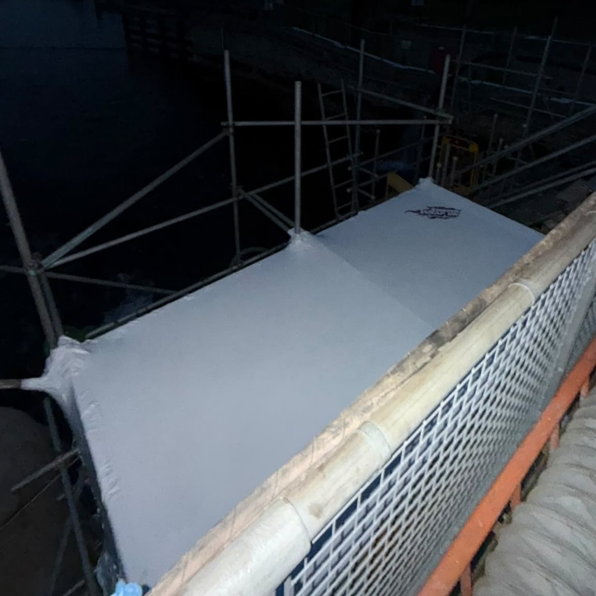 Shrink wrap formed around scaffold on a blasting enclosure