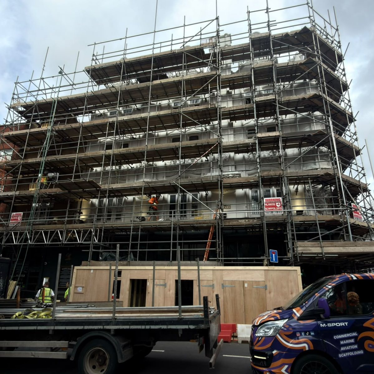 Scaffolded building being surveyed for shrink wrap encapsulation