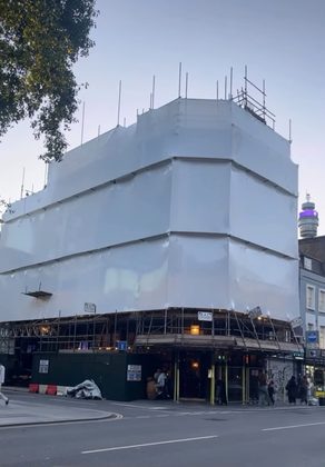 Building encapsulated in shrink wrap over scaffolding — London