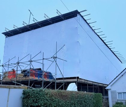 Building encapsulated in shrink wrap over scaffolding