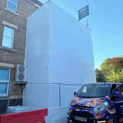 Shrink Wrap UK van beside a fully wrapped building